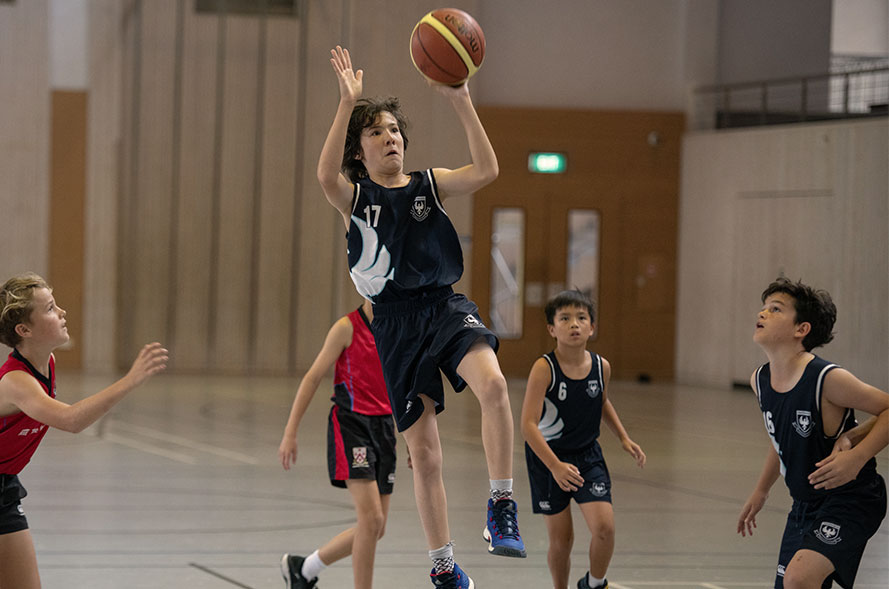 Boys competing in a basketball match