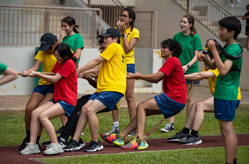 Secondary students playing tug-of-war during sports day