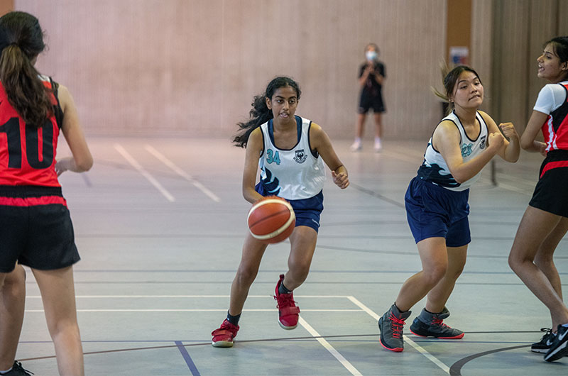 Secondary girls competing in a basketball match