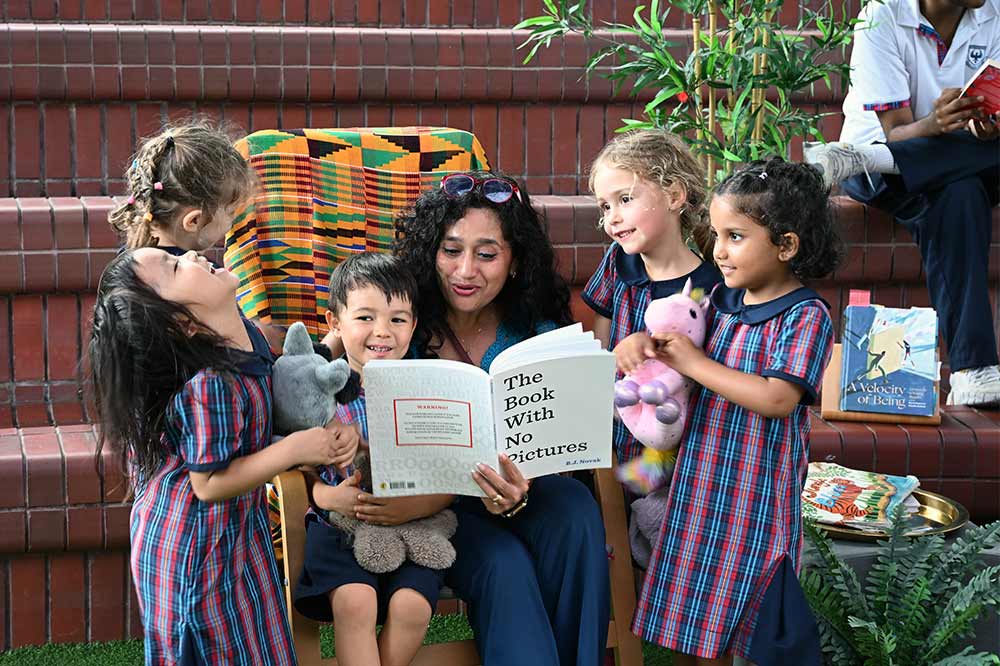 Early years students enjoy reading with their teacher